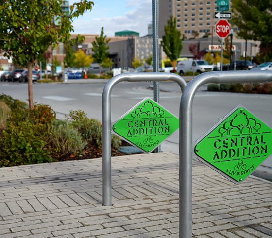 Metal bike racks on the sidewalk of the Broad Street LIV District with green metal cutout designs